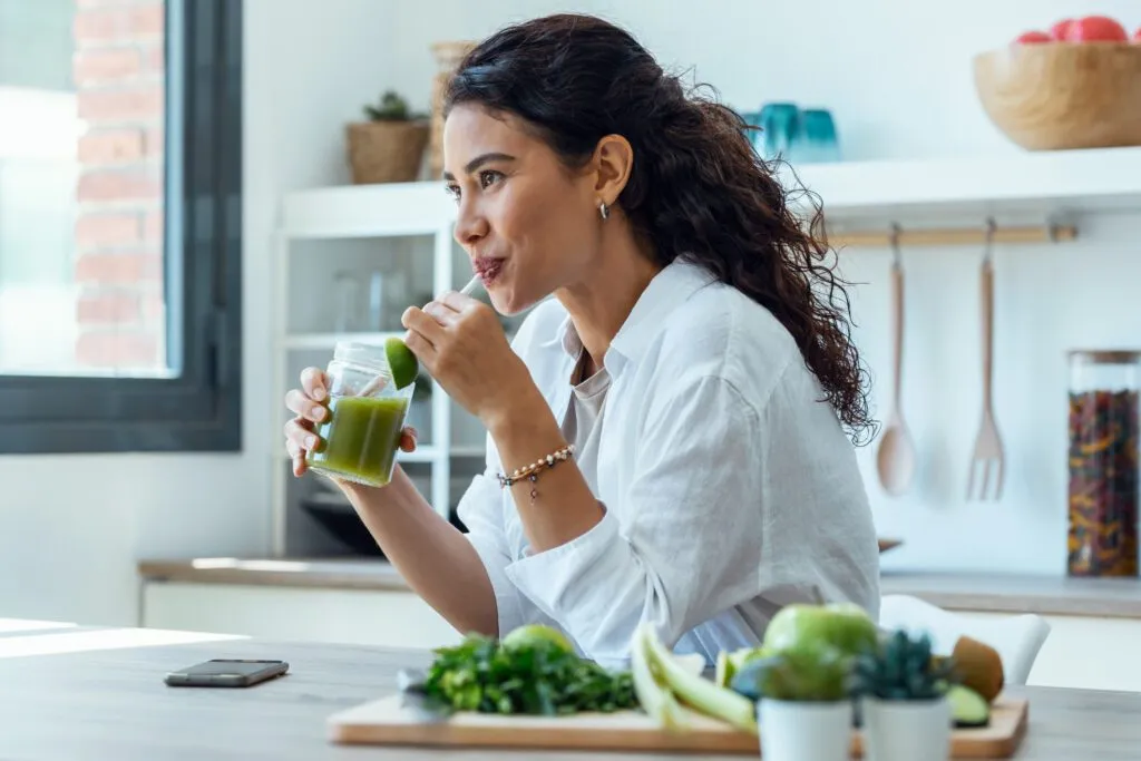 Mujer tomando jugo de verduras verdes